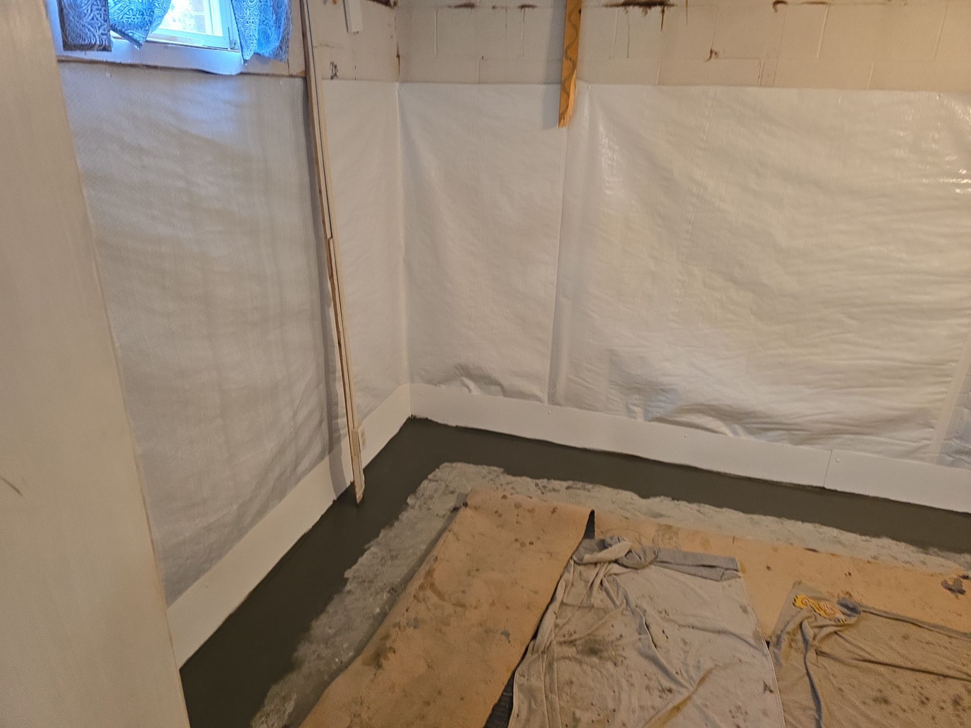 Basement waterproofing crew installing interior drain