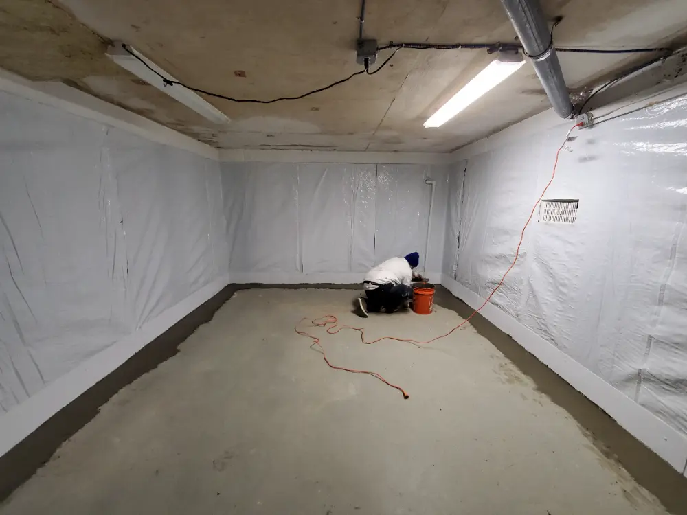Basement waterproofing in progress with sealed walls and interior drainage system installation