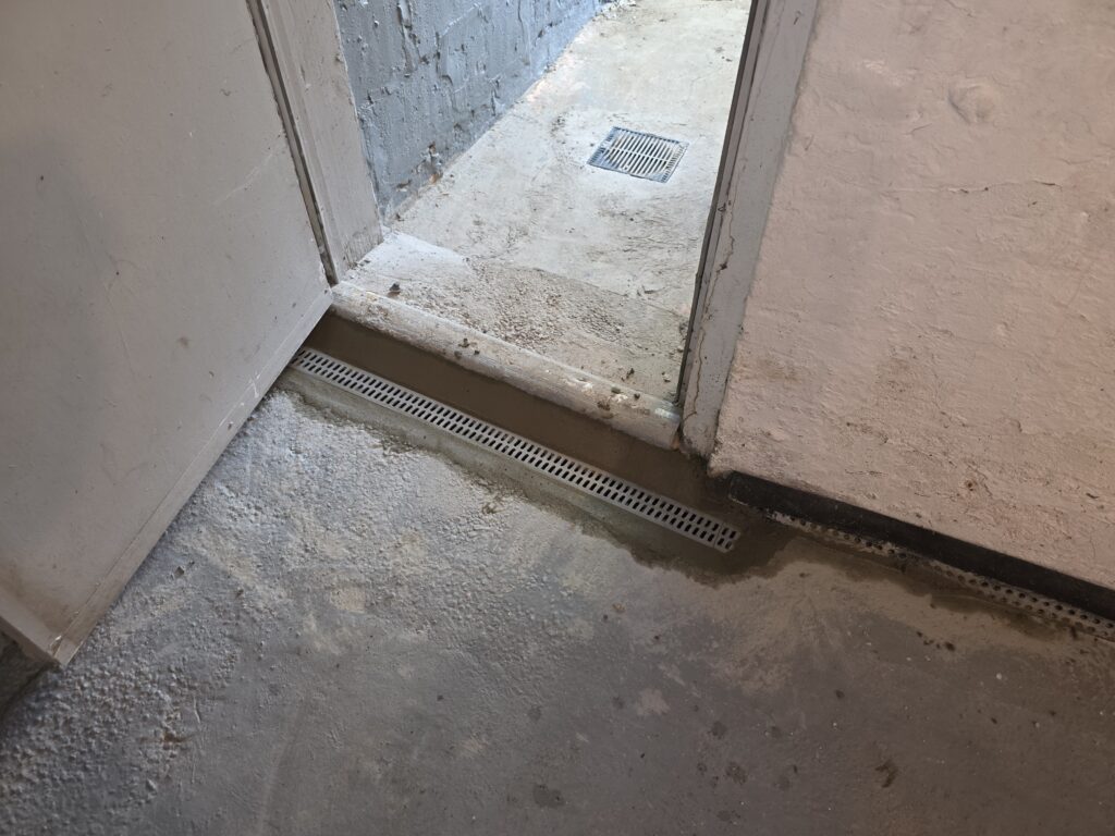 Interior drainage system channel drain installed in a basement floor to prevent water intrusion and manage groundwater.