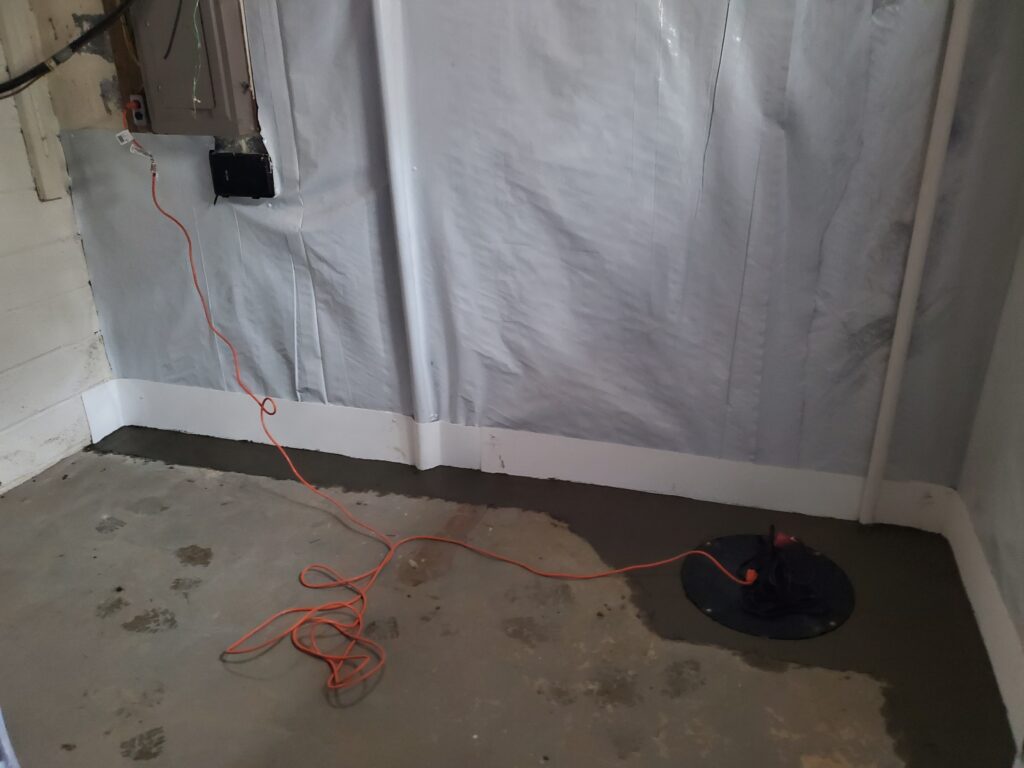 Interior basement drainage system with sump pump installation and vapor barrier wall system
